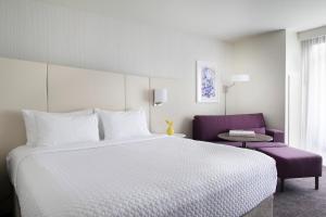 a hotel room with a large bed and a purple chair at Crowne Plaza Hotel Atlanta Perimeter at Ravinia, an IHG Hotel in Atlanta