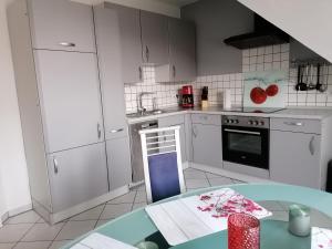 een keuken met witte kasten en een tafel. bij Apartment Grieshop in Dinklage