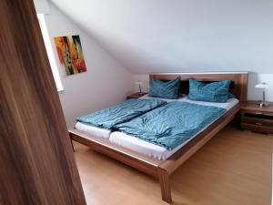 1 dormitorio con 1 cama con mantas y almohadas azules en Apartment Grieshop en Dinklage