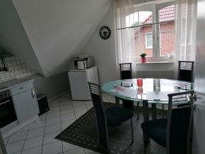 uma cozinha com uma mesa e cadeiras numa cozinha em Apartment Grieshop em Dinklage