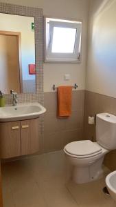 a bathroom with a toilet and a sink and a mirror at Franciscos em Cabanas Golf in Conceição