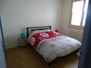 una camera con un letto e un piumone rosso e bianco di Pic de la Corne ad Abondance