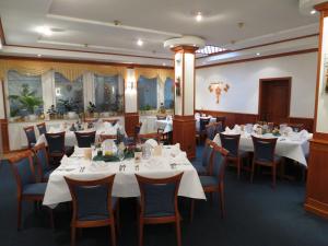 une salle à manger avec des tables et des chaises blanches dans l'établissement Zum Alten Brauhaus, à Hofgeismar