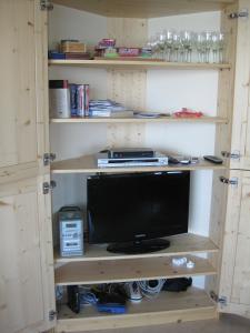 ein Bücherregal mit Computermonitor in einem Zimmer in der Unterkunft Chalet Arc-en-Ciel in Nendaz