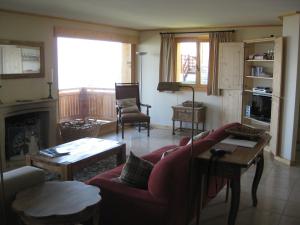 a living room with a red couch and a fireplace at Chalet Arc-en-Ciel in Nendaz