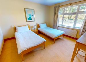 una camera da letto con due letti e una finestra di Fishermans Grove 3 Bed by Trident Holiday Homes a Dunmore East
