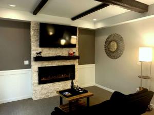 サンダスキーにあるCedar Stables Inn & Suitesのリビングルーム(暖炉、薄型テレビ付)