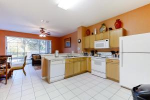 a kitchen with white appliances and a living room at Paradise Palms in Kissimmee