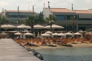 un complejo con sillas y sombrillas en una playa en Alykes Volos, en Volos