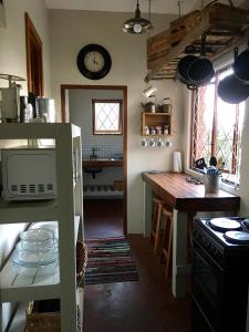 a kitchen with a table and a clock on the wall at Kingfisher Cottage in Umkomaas