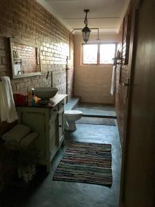 a bathroom with a sink and a toilet and a window at Kingfisher Cottage in Umkomaas