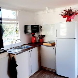 een keuken met een witte koelkast en een wastafel bij Chalet in Narrosse