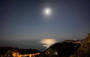 a full moon over the ocean at night at B&B Villa Reginella in Agerola