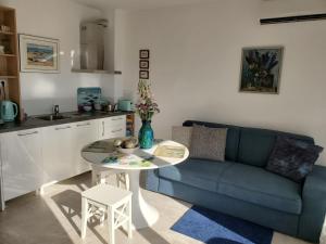 a living room with a blue couch and a table at Obzor Tatyana Apartaments Bonjour in Obzor