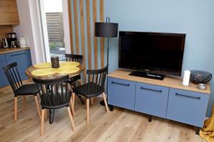 a living room with a table with a tv and a dining room at Chill&Sun Yellow in Łukęcin
