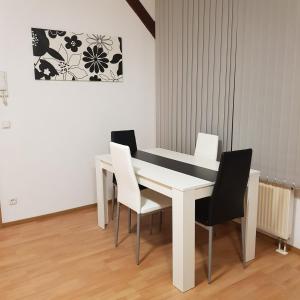 una mesa blanca y sillas en una habitación en Gasthaus Kristall 2, en Salzwedel