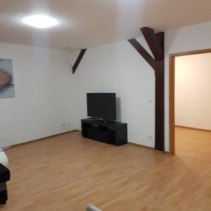 a living room with a tv and a tree on the wall at Gasthaus Kristall 2 in Salzwedel