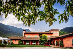 an orange building with mountains in the background at Hotel Al Poggio Verde in Barghe