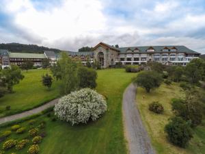 an aerial view of a large building with a grass yard at Hotel Termas Puyehue Wellness & Spa Resort in Puyehue