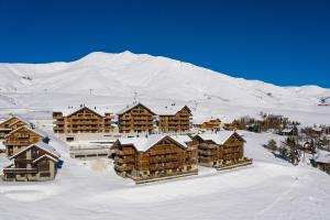 土绪尔ODYSSEE D103 Appartement chaleureux sur les pistes的雪中小屋,背景是一座山