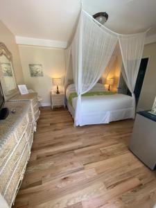 a bedroom with a bed and a dresser at Duval Gardens in Key West