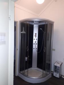 a shower with a glass door in a room at Studio vlak bij het strand in Petten +19 photos