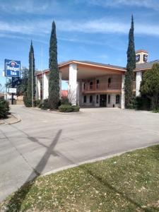 a building with trees in front of a parking lot at Budget Inn San Antonio Downtown I-10 East in San Antonio