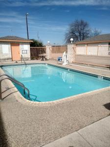 a large swimming pool with a curved walkway around it at Budget Inn San Antonio Downtown I-10 East in San Antonio