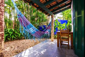 a hammock on a porch with a table at Hotel Aldeia de Sahy in Barra do Sahy +57 photos