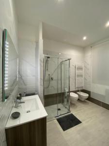 La salle de bains est pourvue d'une douche, d'un lavabo et de toilettes. dans l'établissement Riviera Apartments, à Pescara