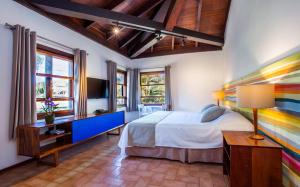 a bedroom with a bed and a desk and a tv at Hotel Aldeia de Sahy in Barra do Sahy