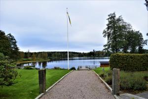 una passerella di fronte a un lago con una bandiera di Torups Gästgivaregård a Torup