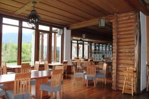 un comedor con mesas, sillas y ventanas en Hotel Termas Puyehue Wellness & Spa Resort, en Puyehue