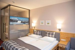 ein Schlafzimmer mit einem großen Bett und einem großen Spiegel in der Unterkunft Hotel Gasthof Zum Kirchenwirt in Puch bei Hallein