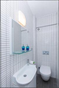 La salle de bains blanche est pourvue d'un lavabo et de toilettes. dans l'établissement Blue Apartments, à Istanbul