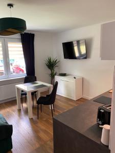 a living room with a table and chairs and a kitchen at Apartament MATEO in Malbork