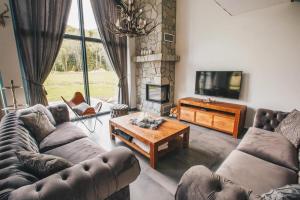 a living room with a couch and a tv and a table at Woodpark Slovianka in Valča