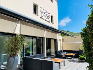 una cafetería con bancos y mesas frente a un edificio en Hotel Centre Nautique en Bonifacio