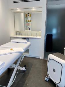 a hospital room with a bed and a sink at Hotel Centre Nautique in Bonifacio