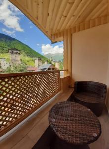 einen Balkon mit einer Bank, einem Tisch und einem Fenster in der Unterkunft Sanli in Mestia