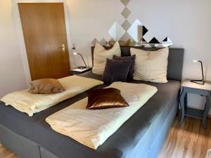 uma cama com duas almofadas em cima em Apartment "Im Sonneneck" bis 4 Personen mit Parkplatz, W-LAN, Netflix im Thüringer Wald, Schleusingen em Schleusingen