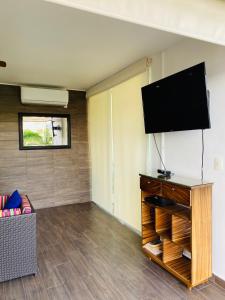 Una sala de estar con un televisor de pantalla plana en una pared. en vista al mar y alberca infinita aria ocean nvo vallarta, en Nuevo Vallarta 