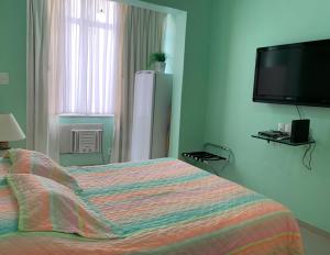 1 dormitorio con 1 cama y TV de pantalla plana en Studio Copacabana 1003, en Río de Janeiro