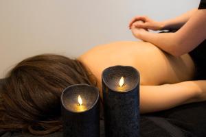 a pregnant woman laying on a bed with two candles at Hotel Spa Genovese in Bonifacio