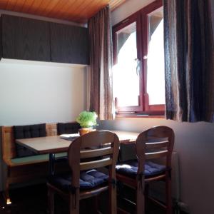 a dining room table with two chairs and a window at Chalet-Schümli Maisonette in Ernen