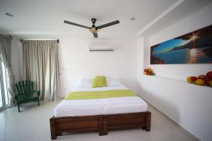 Hotel Playa Blanca - San Antero في سان أنتيرو: غرفة نوم بسرير ومروحة سقف