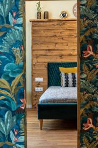 sypialnia z łóżkiem z tropikalną tapetą w obiekcie Zur Linde w Sybinie