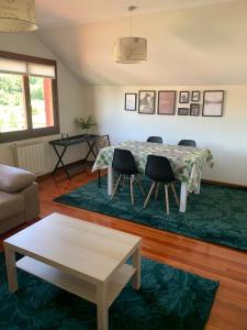 ein Wohnzimmer mit einem Tisch, Stühlen und einem Sofa in der Unterkunft Apto Valle Encantado, vistas preciosas en urbanización con piscina in Gibaja