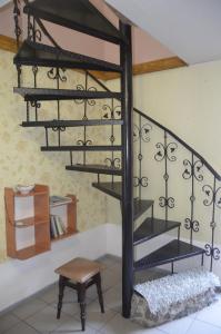 a metal spiral staircase in a room with a stool at Апартаменти в Будиночку біля Софіївського Парка in Umanʼ