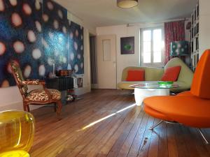 - un salon avec un canapé, une table et des chaises dans l'établissement Maison d'hôtes des Perrières, à Dijon